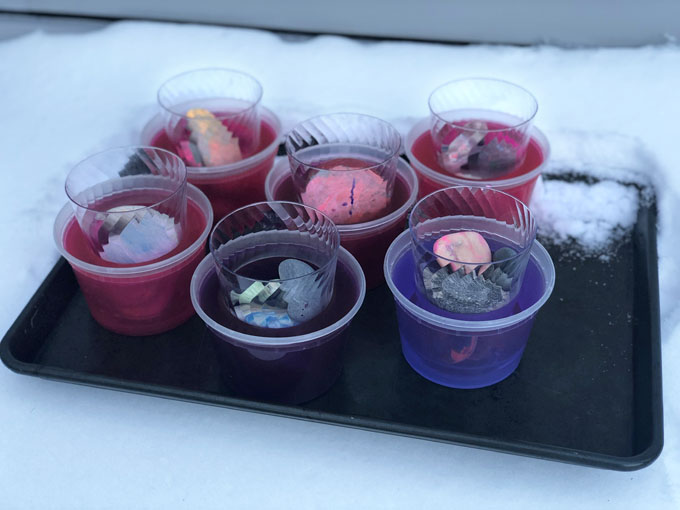 Préparez de simples votives à glace en congelant de l'eau pendant la nuit dans un contenant de charcuterie et en ajoutant du colorant alimentaire.  Un bel ajout à votre fête pandémique en plein air!