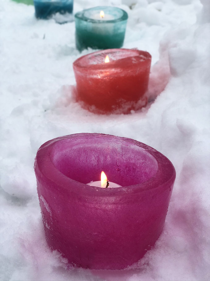 Préparez de simples votives à glace en congelant de l'eau pendant la nuit dans un contenant de charcuterie et en ajoutant du colorant alimentaire.  Un bel ajout à votre fête pandémique en plein air!