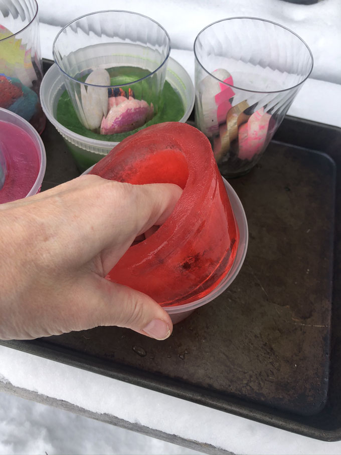 Préparez de simples votives à glace en congelant de l'eau pendant la nuit dans un contenant de charcuterie et en ajoutant du colorant alimentaire.  Un bel ajout à votre fête pandémique en plein air!