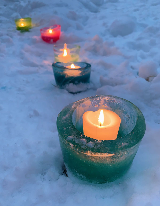 Préparez de simples votives à glace en congelant de l'eau pendant la nuit dans un contenant de charcuterie et en ajoutant du colorant alimentaire.  Un bel ajout à votre fête pandémique en plein air!