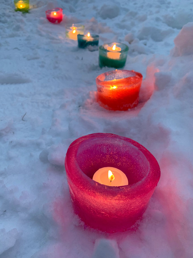 Préparez de simples votives à glace en congelant de l'eau pendant la nuit dans un contenant de charcuterie et en ajoutant du colorant alimentaire.  Un bel ajout à votre fête pandémique en plein air!