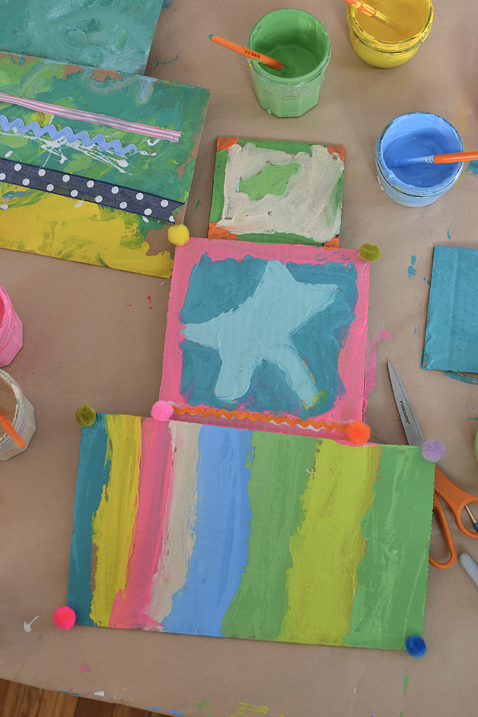 Mélanger les couleurs de peinture à l'aide de peintures à la détrempe pour peindre des beignets géants en carton.