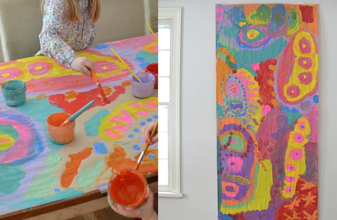 Peinture sur une table recouverte de papier de boucherie à l'aide de peintures à la détrempe.