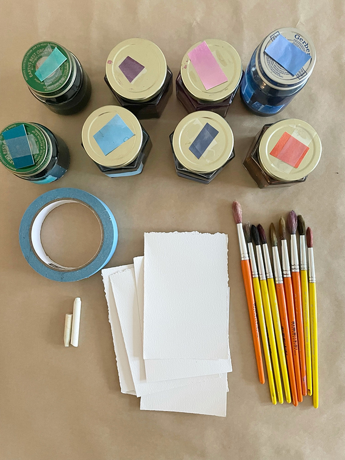 Fabriquez une guirlande de maison peinte en utilisant une technique d'aquarelle liquide et de ruban adhésif.