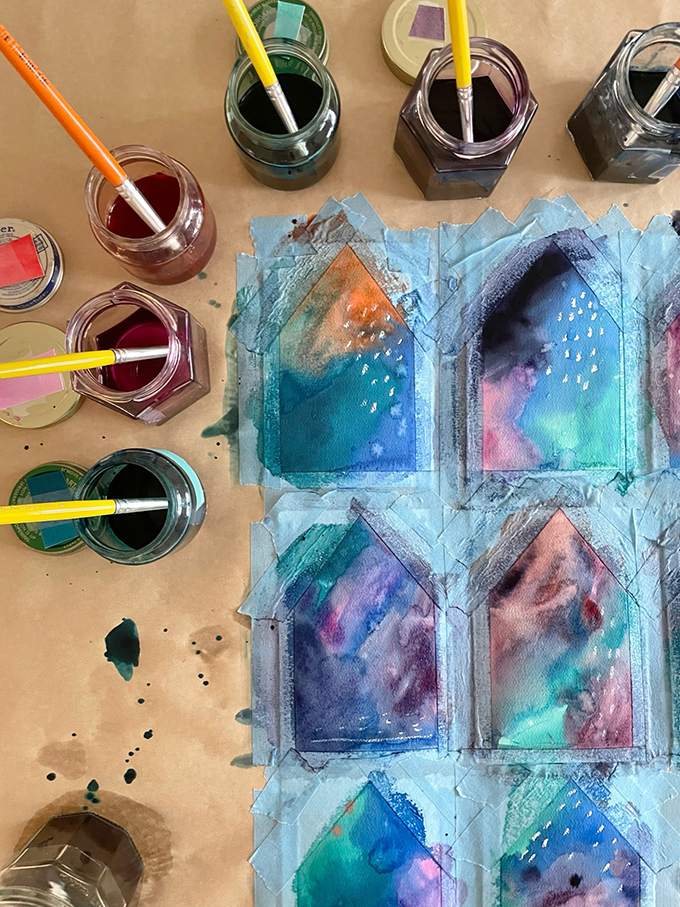 Fabriquez une guirlande de maison peinte en utilisant une technique d'aquarelle liquide et de ruban adhésif.