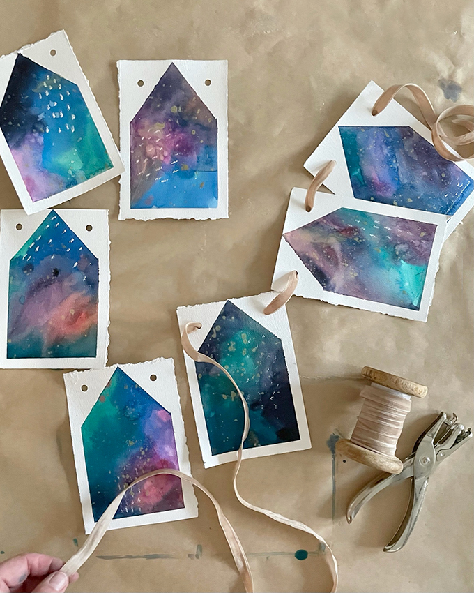 Fabriquez une guirlande de maison peinte en utilisant une technique d'aquarelle liquide et de ruban adhésif.