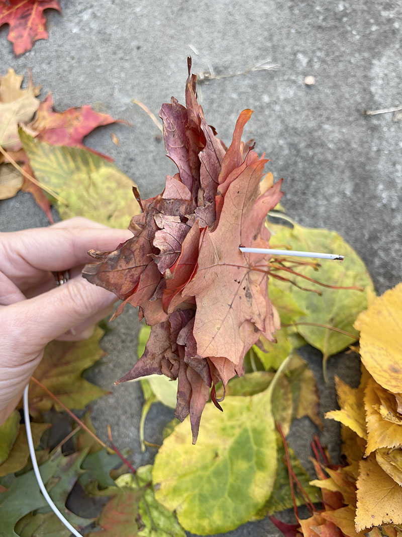 Faites une simple couronne de feuilles arc-en-ciel à l'aide d'un cintre métallique. 