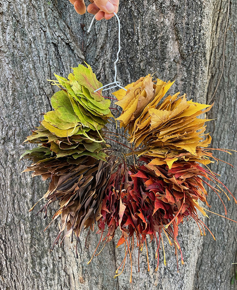 Faites une simple couronne de feuilles arc-en-ciel à l'aide d'un cintre métallique.