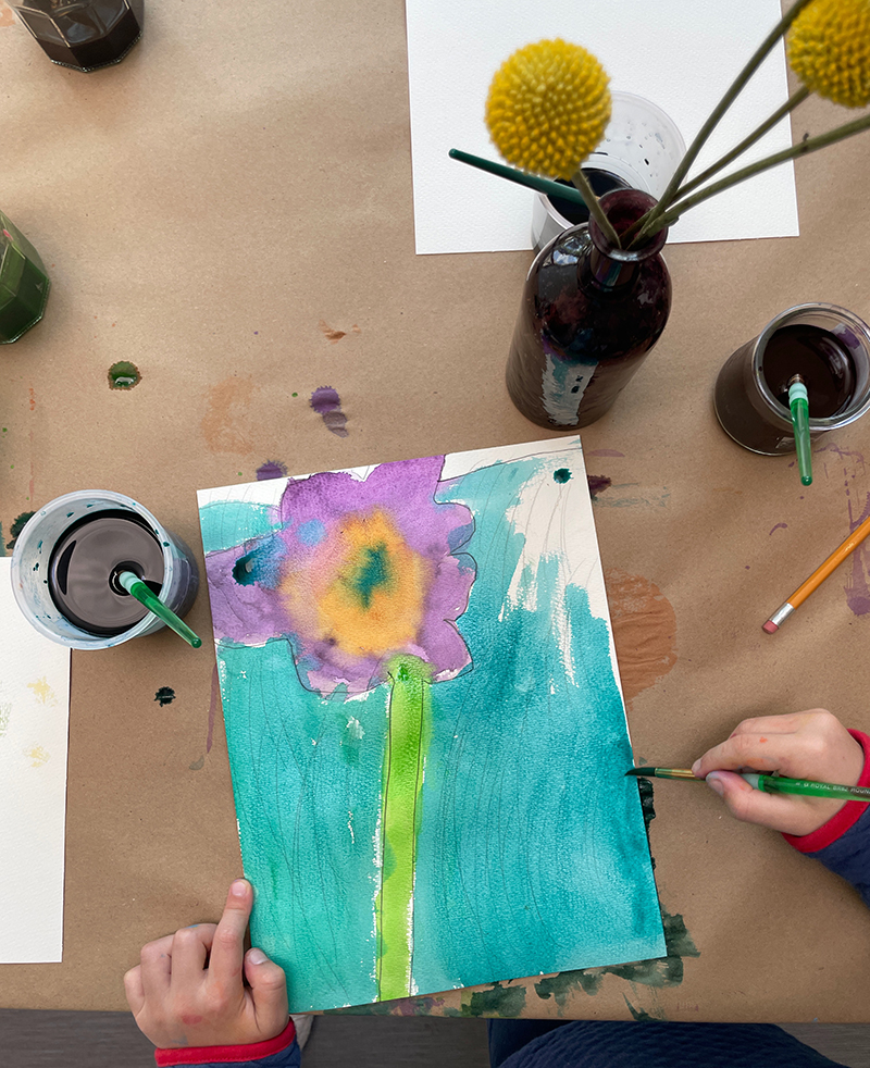 Dessin de nature morte de fleurs d'observation par un jeune enfant à l'aide d'aquarelle liquide.