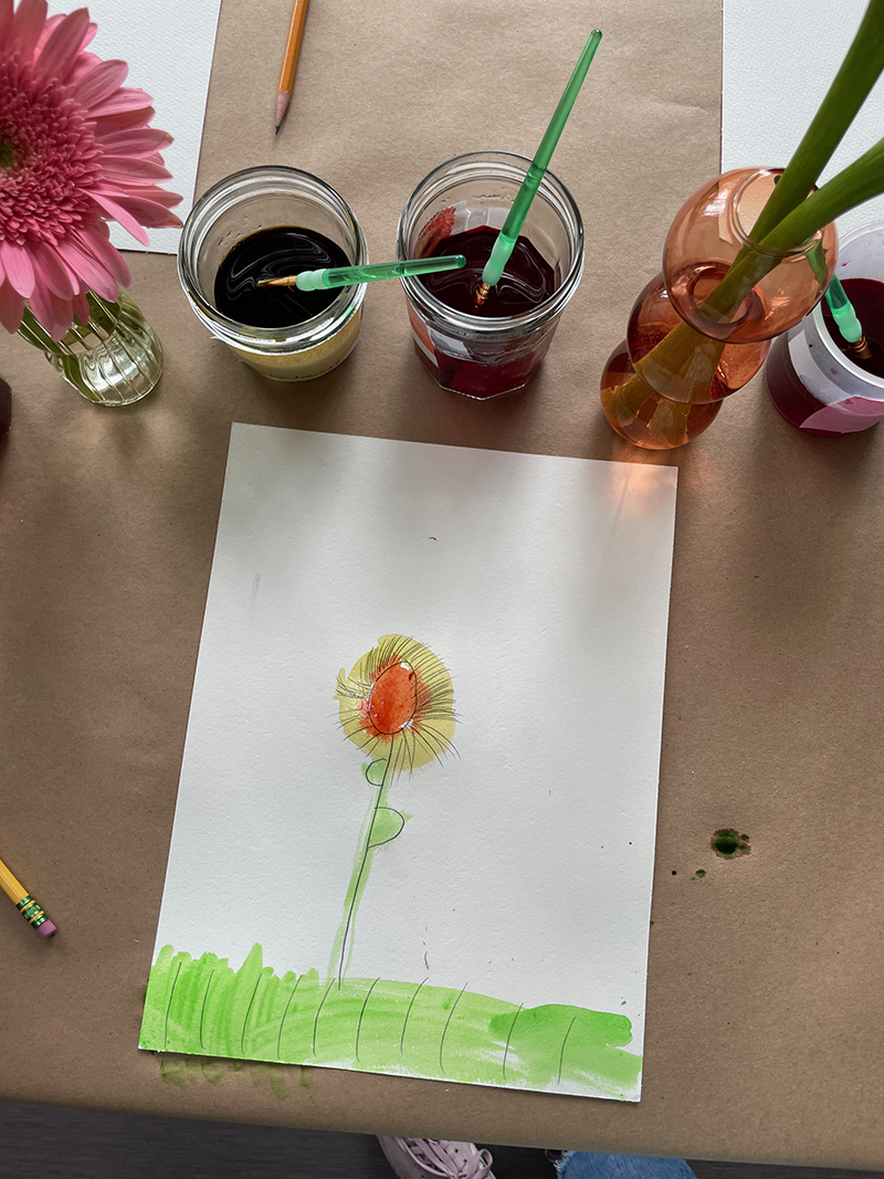 Peinture de nature morte de fleurs par un jeune enfant à l'aide d'aquarelle liquide.