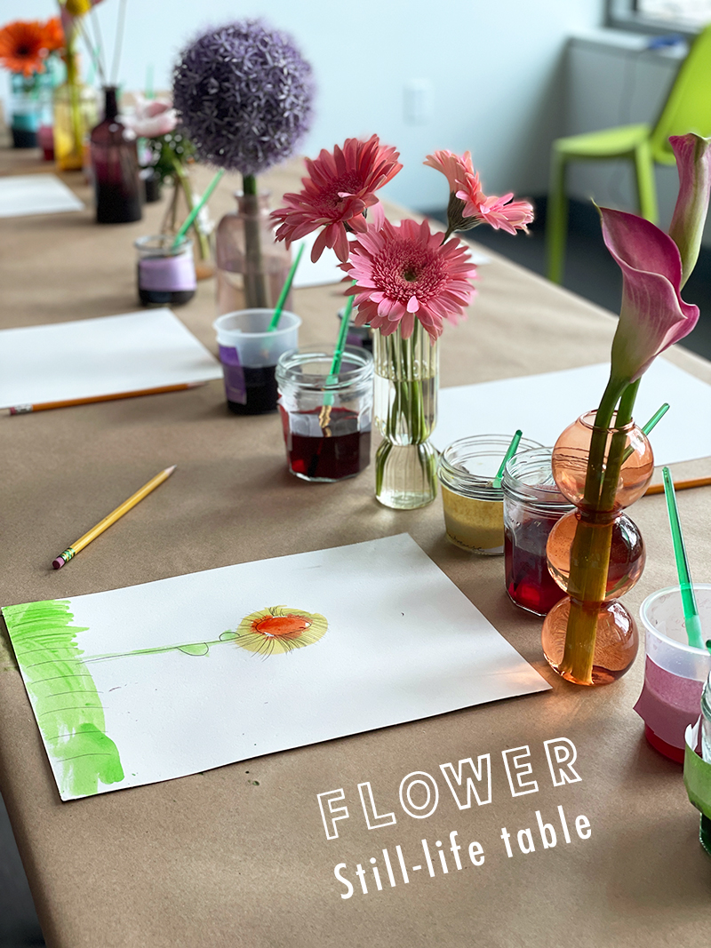 Tableau plein de petits vases à bourgeons, fleurs, papier, crayons et aquarelles.